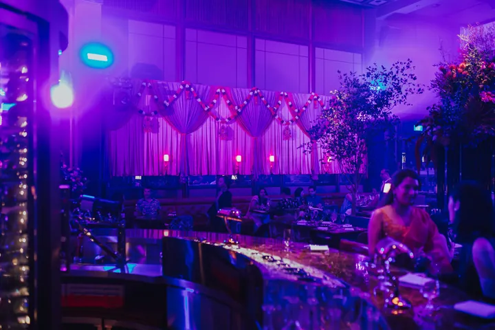 Diwali 2024: Draped, garland-hung stage backdrop under violet lighting