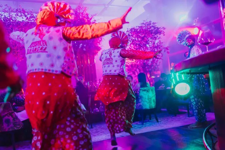 Diwali 2024: Bhangra dancers in the main room under colour-wash lighting