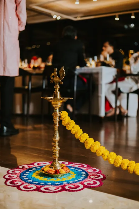 Diwali 2025: Brass lamp on a rangoli, marigold rope barriers guiding the entrance