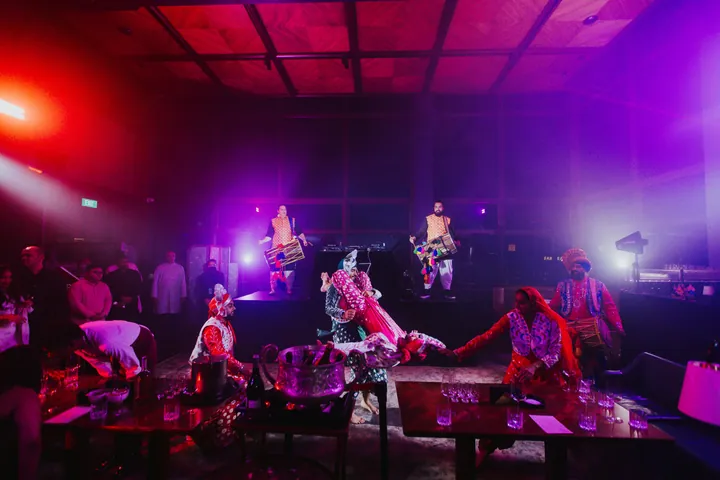 Diwali 2025: Dancers between the tables under red and violet lighting