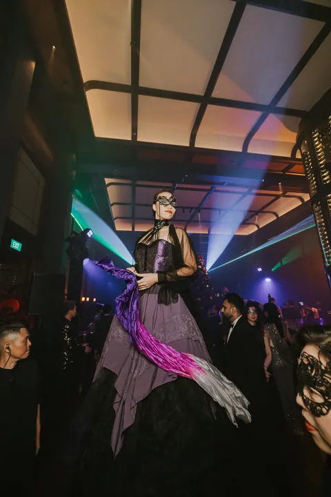 New Year's Eve 2024 · Masquerade: A costumed performer with a fan, beams cutting through the haze
