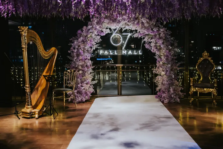New Year's Eve 2025 · Wisteria: Wisteria ceiling, floral arch framing the neon 67 Pall Mall sign, gold harp and throne
