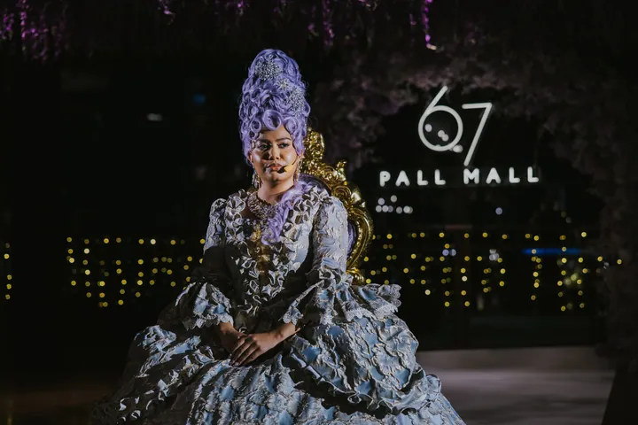 New Year's Eve 2025 · Wisteria: A costumed performer on the gold throne beside the neon sign