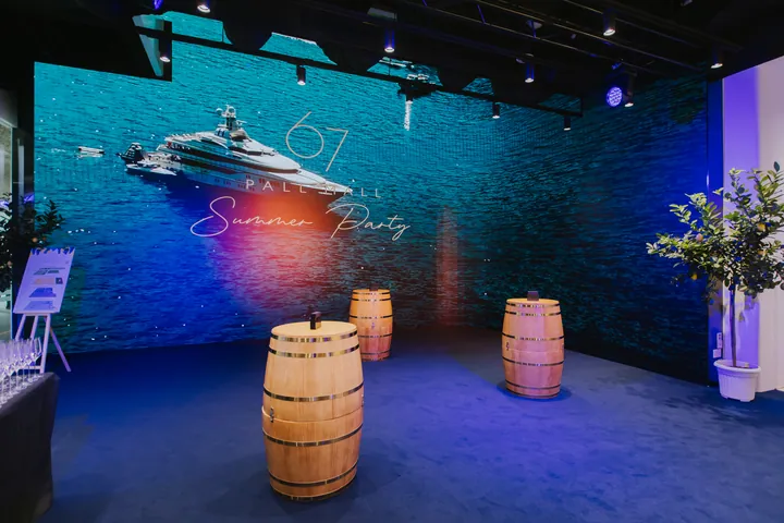 Summer Party 2026: LED wall with the club's Summer Party artwork, wooden barrels on a blue-lit floor