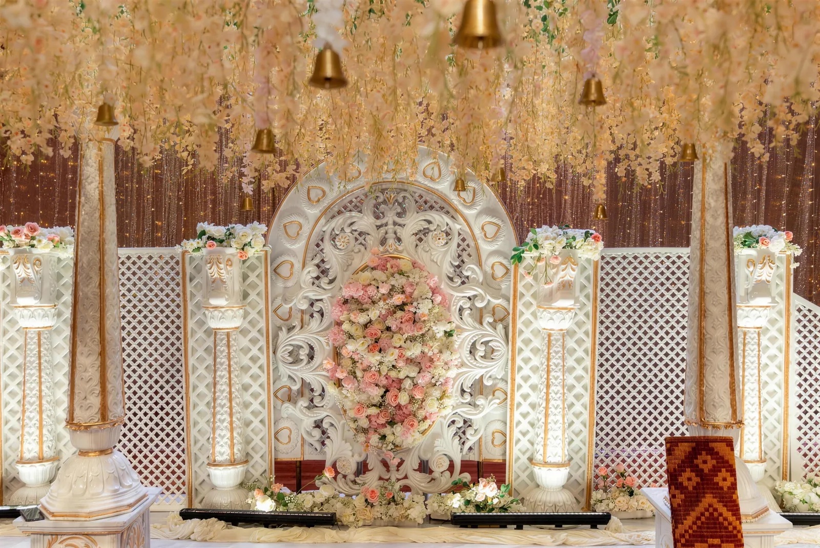 White carved stage with pink florals at PGP Hall
