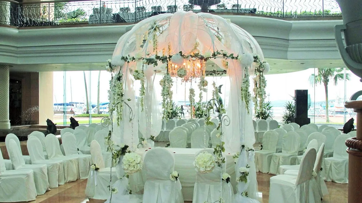 The Atrium at Raffles Marina set for a solemnisation, with yachts beyond the glass